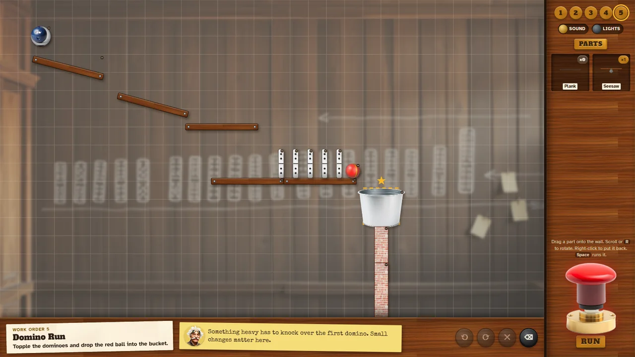 The game: a domino run on a wooden shelf, planks guiding a bowling ball down from the top left, a bucket on a brick pillar, and the toolbox with the big red Run button on the right.